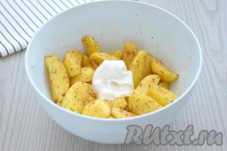 К картошке, смешанной со специями, добавляем сметану и растительное масло.