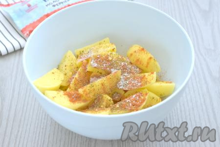 В миску с дольками картошки всыпаем соль и специи (в качестве специй я добавила паприку, сушёную зелень и 1 чайную ложку&nbsp;приправы для картофеля).