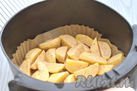 Застилаем чашу аэрогриля пергаментом, затем выкладываем картошку, покрытую сметаной и специями. Отправляем чашу с картофелем в аэрогриль. Включаем аэрогриль на 180 градусов, устанавливаем время - 35 минут.