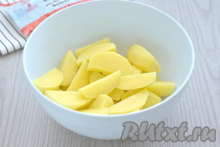 Нарезаем картофель на небольшие дольки, перекладываем их в миску.