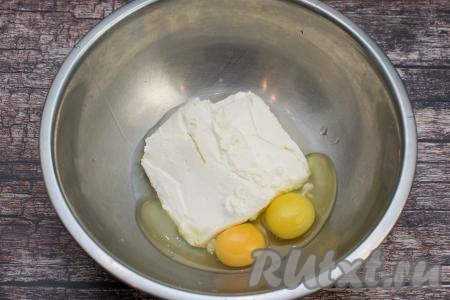 В глубокую миску выложить творог и сырые яйца.