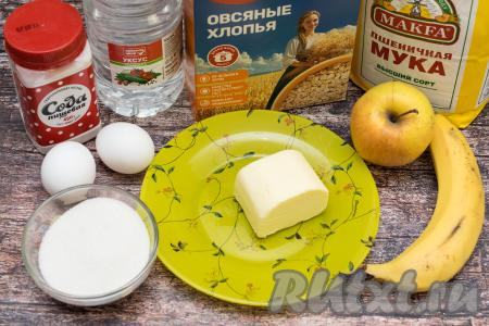 Подготовить продукты для приготовления овсяного печенья с яблоками и бананом. Овсяные хлопья можно взять любые быстрого приготовления (то есть на упаковке время приготовления должно быть указано 5 минут). Банан и яблоко лучше взять спелые, чтобы не добавлять лишний сахар в печенье. Сливочное масло для замешивания теста должно быть мягким, поэтому его из холодильника нужно достать заранее, чтобы оно успело согреться до комнатной температуры.