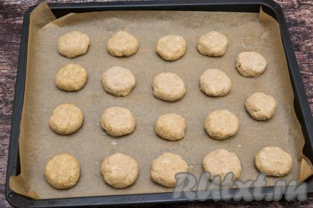 Руками, смоченными водой, отщипывать от теста небольшие кусочки (я стараюсь отщипывать кусочки весом примерно 30 грамм). Из каждого кусочка теста формировать шарик размером чуть больше грецкого ореха. Сформированные шарики выкладывать на противень, застеленный пергаментом, на небольшом расстоянии друг от друга (всего у меня получились 19 шариков). Слегка прижать каждый шарик сверху ладонью, чтобы он стал похож на толстую лепёшку.