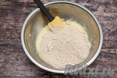 В миску с масляно-яичной массой всыпать измельчённые овсяные хлопья.