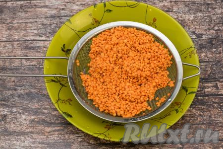 Налить в кастрюлю 2,5 литра воды, поставить на сильный огонь, довести до кипения. Пока закипает вода, чечевицу выложить в сито, тщательно промыть под проточной водой, лишней воде дать стечь.