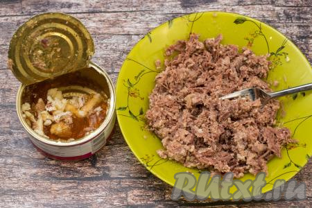 Открыть банку тушёнки. Выложить на тарелку тушёнку без жира, размять кусочки мяса вилкой.