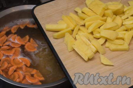Сразу же выложить в кастрюлю очищенную картошку, нарезанную на средние брусочки. Дать супу закипеть, уменьшить огонь, варить под крышкой 10 минут.