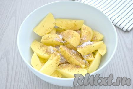 Дольки картошки посыпаем солью и специями (в качестве специй я использовала 1 чайную ложку приправы для картофеля). Перемешиваем, покрывая картофель специями со всех сторон.