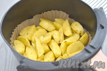 Чашу аэрогриля застилаем пергаментом, выкладываем дольки картошки, отправляем чашу в аэрогриль. Температуру устанавливаем 180 градусов, время - 35 минут. Я готовила в аэрогриле мощностью 1400 Ватт.