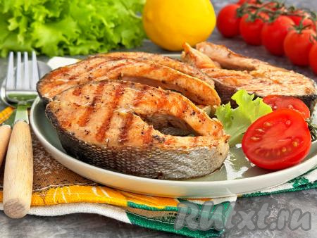 Готовые стейки из форели переложить со сковороды гриль на тарелку и подать к столу в горячем виде, дополнив гарниром или свежими овощами. Перед подачей можно сбрызнуть рыбку лимонным соком.