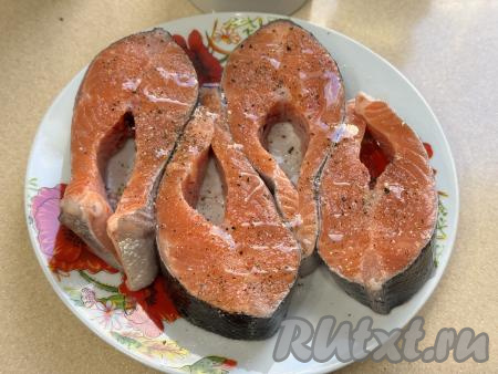 Стейки из форели посолить и поперчить с двух сторон (можно взять любимые специи для рыбы). Сбрызнуть рыбу сверху растительным маслом, втереть специи в стейки. Оставить стейки на 15 минут на кухонном столе, чтобы они пропитались специями.