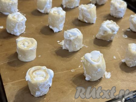 На противень, застеленный ковриком (или пергаментом) для выпечки, поставить кусочки рулета срезом вверх на расстоянии друг от друга.&nbsp;