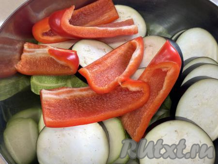 Болгарский перец очистить от плодоножки и семян, промыть водой. Нарезать перец на широкие дольки или, в зависимости от размера, разрезать пополам, добавить в миску с кабачками и баклажанами.