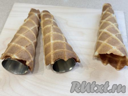 Готовую горячую вафлю сразу завернуть на железный конус для трубочек и оставить остывать. Если нет специальных конусов, тогда можно просто сворачивать вафли в трубочки. 