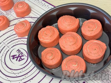 Форму для выпечки&nbsp;диаметром 26 сантиметров смазать растительным маслом, выложить 7 синнабонов "Красный бархат" так, чтобы было небольшое расстояние между булочками. У меня это самая большая форма и в неё все синнабоны не поместились, остальные булочки я выпекала на противне, застеленном пергаментом, разложив их на небольшом расстоянии друг от друга.