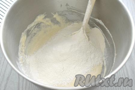 Далее в получившееся тесто всыпаем соль, начинаем частями просеивать оставшуюся муку, каждый раз хорошо вмешивая муку лопаткой. Когда тесто станет достаточно густым, его будет сложно перемешивать лопаткой, начинаем вымешивать его руками, всыпая муку только по мере необходимости, очень хорошо вмешивая её.