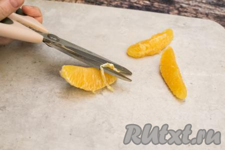 Апельсин очистить от кожуры, разделить на дольки. Очистить дольки апельсинов от плёночек. Косточки, если они есть, нужно удалить. Я достаточно часто для приготовления различных блюд очищаю дольки апельсинов от плёночек, поэтому нашла, на мой взгляд, самый простой и быстрый способ очищения. Вначале с помощью кухонных ножниц я отрезаю плёночку на самой узкой части дольки, а затем руками с двух сторон убираю плёнку с дольки. Благодаря ножницам, очищение долек апельсина от плёночек проходит очень быстро.