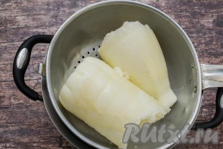 Расколоть ножом ледяной кефир на две части и поместить в дуршлаг. Дуршлаг с замороженным кефиром поставить поверх кастрюли, в которую будет стекать жидкость в процессе размораживания кефира. Накрыть сверху дуршлаг и оставить в таком виде конструкцию на несколько часов (до полного размораживания и стекания жидкости). Я оставляю примерно на 7-8 часов, можно на ночь оставить.