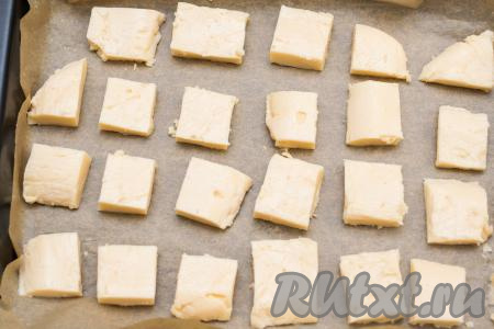 Форму для выпечки застелить пергаментом. Выложить на пергамент кусочки молочного десерта.