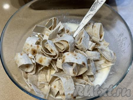 Остальной лаваш нарезать на полоски шириной примерно 1,5 сантиметра. Выложить нарезанный лаваш в миску с яично-молочной смесью.