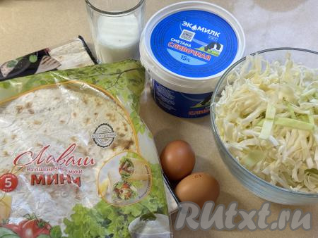 Подготовить продукты для приготовления пирога с капустой из лаваша в духовке. Капусту вымыть, удалить верхние и испорченные листья. 500 грамм капусты нарезать на тонкие полоски. Сметану и молоко можно взять любой жирности.