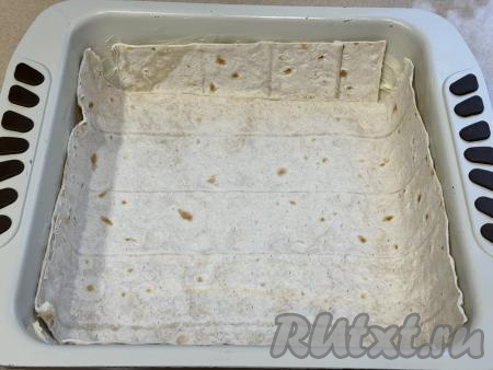 Лаваш я купила уже нарезанный на 5 равных частей, при необходимости нарежьте лаваш на листы нужного размера. Выложить сначала один лист лаваша в форму для запекания, чтобы он заходил на два бортика формы, затем сверху положить ещё один лист лаваша, чтобы он закрывал два других бортика. Ещё один лист лаваша отложить, чтобы в дальнейшем закрыть сверху начинку пирога.