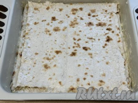 Подогнуть края лаваша с бортиков, накрыть начинку отложенным ранее листом лаваша, закрывая всю начинку.