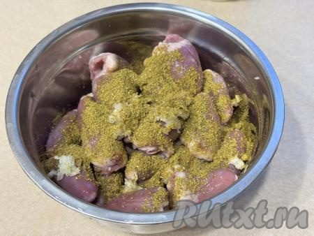Подготовленные куриные сердечки выложить в достаточно глубокую миску, добавить специи (в качестве специй я использовала&nbsp;0,5 чайной ложки&nbsp;хмели-сунели) и&nbsp;пропущенный через пресс чеснок.