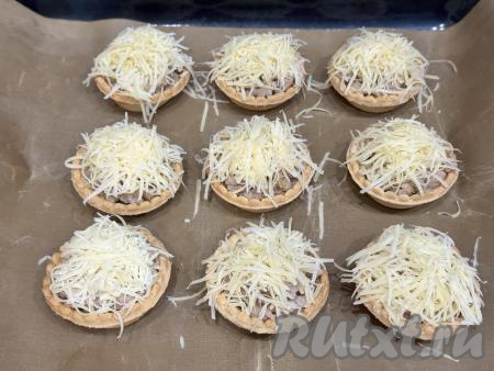 Сыр натереть на мелкой тёрке и выложить поверх фарша.&nbsp;