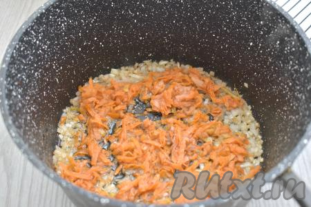 К луку, обжаренному до прозрачности, выкладываем натёртую на крупной тёрке морковь, сразу перемешиваем овощи. Обжариваем овощи, время от времени перемешивая, минут 5 (морковка должна стать достаточной мягкой).