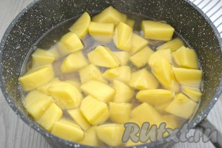 Свиные рёбрышки с капустой и картошкой полностью заливаем горячей водой, аккуратно перемешиваем. На достаточно сильном огне даём воде закипеть, убавляем огонь, накрываем крышкой, тушим до готовности картофеля (ориентировочно в течение 25 минут, картошка должна стать достаточно мягкой, легко прокалываться вилкой, но при этом она должна хорошо держать форму).