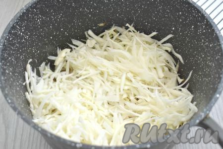 К обжаренным луку и морковке добавляем капусту, нарезанную на тонкие полоски, перемешиваем, жарим 10-12 минут (капуста должна стать достаточно мягкой), иногда перемешивая.