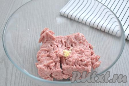 Для формирования фрикаделек можно взять как фарш, приготовленный в домашних условиях (для получения фарша нужно взять любое мясо и пропустить его через мясорубку), так и покупной фарш. Я использовала покупной фарш из свинины. В достаточно глубокую миску выкладываем фарш, добавляем пропущенный через пресс чеснок.