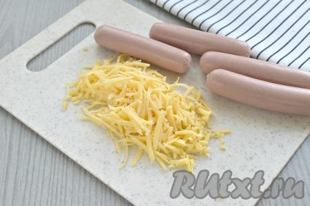 Сыр натираем на крупной тёрке. С сосисок снимаем оболочку.