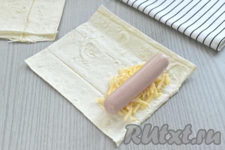 Поверх сыра кладём сосиску.