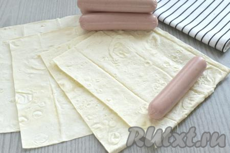 Тонкий лаваш нарезаем на прямоугольники (количество прямоугольников из лаваша должно быть равно количеству сосисок, которые вы будете готовить). Ширина прямоугольника из лаваша должна быть на 2-3 сантиметра больше, чем длина сосиски. Длина прямоугольника из лаваша должна быть ориентировочно 17-20 сантиметров. Мне потребовались 4 прямоугольника из тонкого лаваша шириной 14 сантиметров и длиной 18 сантиметров.