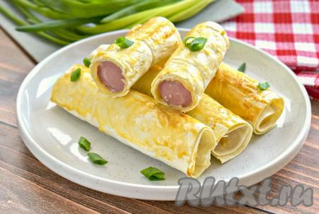 Готовые сосиски, запечённые с сыром в лаваше, достаём из аэрогриля и горячими подаём к столу.&nbsp; Это простое, вкусное, достаточно сытное блюдо можно подать и на завтрак, и на полдник, можно взять и в качестве перекуса на работу.