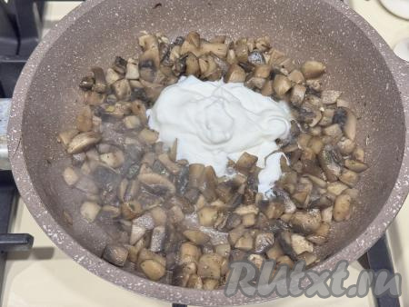 В сковороду с обжаренными грибами добавить сметану.&nbsp;