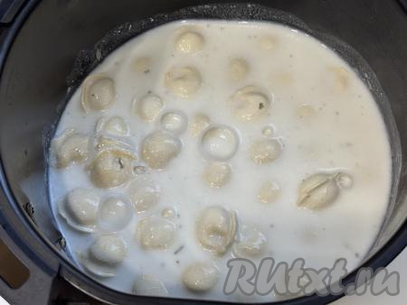 Влить получившийся сметанный соус в чашу аэрогриля к пельменям. Соус должен практически полностью покрывать пельмени, если необходимо, добавьте ещё немного кипящей воды. Чашу с пельменями в сметане отправить в аэрогриль. Выставить температуру 200 градусов, время - 20 минут.