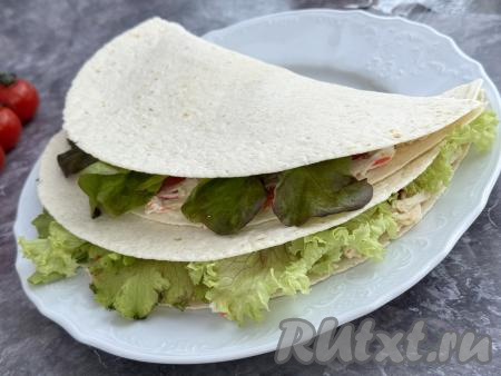 Таким же образом сформировать ещё 3 тортильи с начинкой из крабовых палочек, яиц, помидоров и листьев салата.