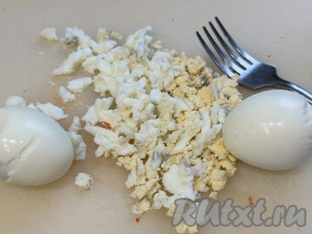 Остывшие варёные яйца почистить и размять вилкой.