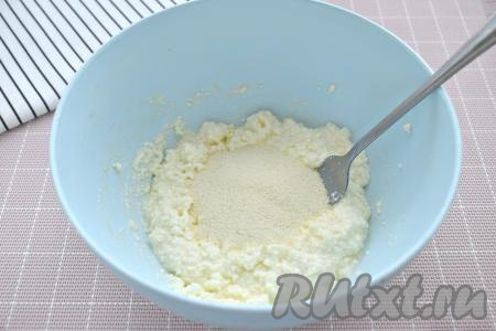 В получившуюся однородную творожную&nbsp;массу всыпаем 1 столовую ложку манки, тщательно перемешиваем, всыпаем ещё 1 столовую ложку манки, снова хорошо перемешиваем.