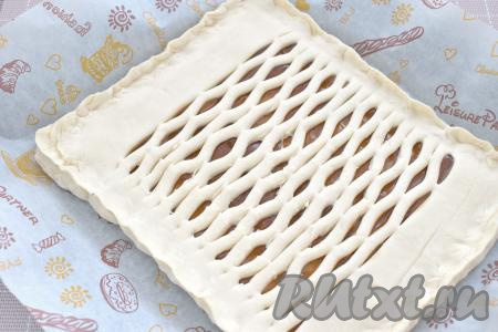 Пластом теста с надрезами накрываем пласт теста с начинкой, растягивая немного края пласта с надрезами. На месте разрезов получаются красивые отверстия. Тщательно скрепляем края пирога.