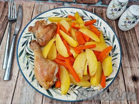 Форму с готовым блюдом достать из духовки. Сочные кусочки курицы вместе с аппетитными, нежными картошкой и морковкой разложить по тарелкам и в горячем виде подать вкусное, насыщенное блюдо к столу.