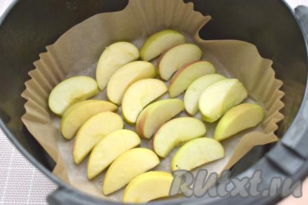 Чашу аэрогриля застилаем пергаментом, выкладываем дольки яблок в один слой.