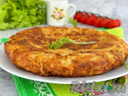 Сковороду с готовым пирогом из лаваша с капустой убрать с огня. Дать немного остыть, а затем переложить со сковороды на тарелку.