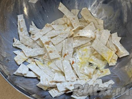 Перемешать содержимое миски, покрывая полоски лаваша яйцом и молоком со всех сторон.