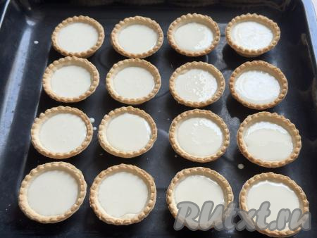 Разложить сметанную массу по тарталеткам, заполняя примерно на 2/3 объёма.