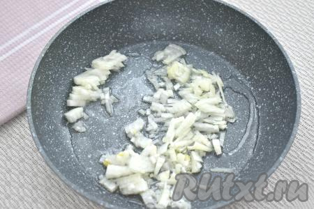 Пока варятся рис и картошка, сразу приступаем к обжарке овощей. Для этого хорошо прогреваем растительное масло в сковороде, выкладываем очищенный и мелко нарезанный лук. Обжариваем лук на среднем огне до мягкости (минуты 3-4), иногда помешивая.