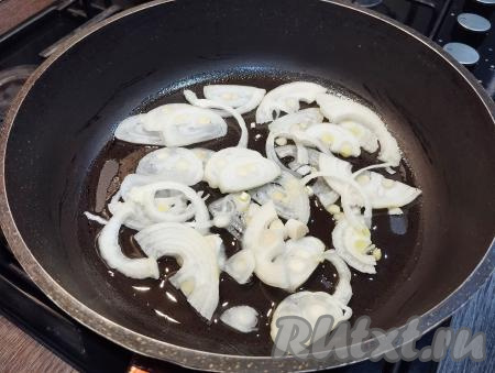 В сковороде прогреваем немного растительного масла, выкладываем полукольца лук. Обжариваем лук на среднем огне, периодически перемешивая, до мягкости (буквально минуты 3), не накрывая сковороду крышкой.